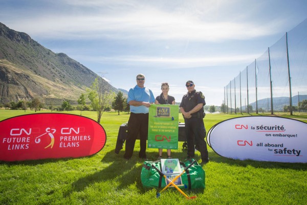 Peter Sampson, Assistant Superintendant at CN and Constable Mark Chupik, CN Police presenting a Golf in Schools banner to Ms . Cody Kelsey from Sk’elep School of Excellence at Mount Paul Golf Course in Kamloops, BC, one of the 15 schools adopted by CN through the 2015 CN Future Links Community Tour. (CNW Group/CN)