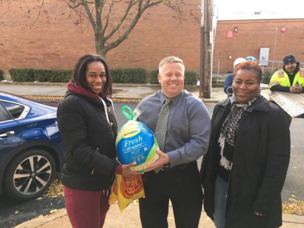 Eric Casey, CEO GT USA Wilmington and Angela Ringgold, Bancroft Elementary School (right)hand turkeys out to parents of the school children.