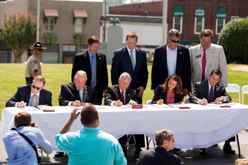 Officials gather to sign a Memorandum of Agreement establishing the Appalachian Regional Port, Tuesday, July 28, 2015, in Chatsworth, Ga. From left, CSX Executive Vice President Clarence Gooden, Georgia Speaker of the House David Ralston, Georgia Gov. Nathan Deal, Murray County Commissioner Brittany Pittman, and Georgia Ports Authority Executive Director Curtis Foltz. 