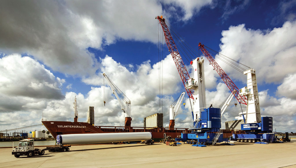 Mobile harbor cranes work in tandem as a wind energy tower section is lifted into place at the Port of Brownsville’s recently dedicated Cargo Dock No. 16