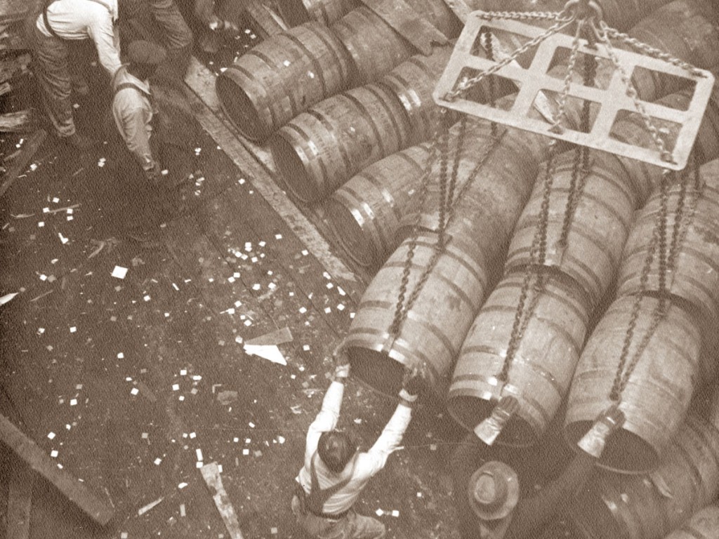 A 1955 photo shows workers unloading barrels from a vessel berthed at the emerging Port of Savannah.