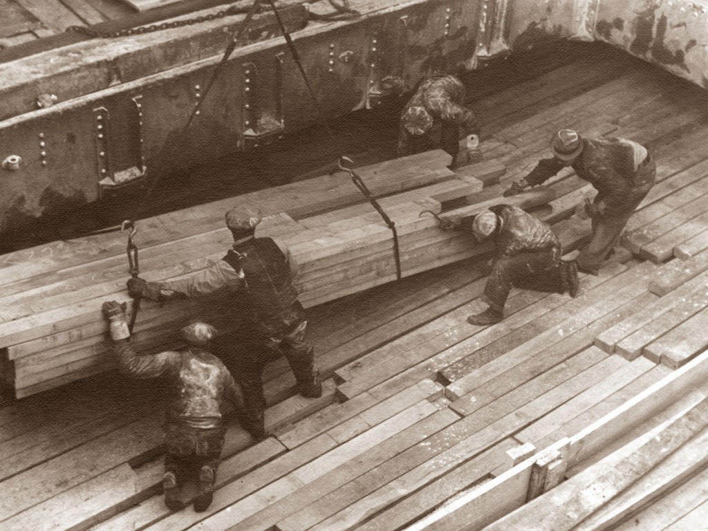 Dockworkers load lumber into the hold of a vessel at the Port of Savannah in 1955, prior to the advent of containerization.