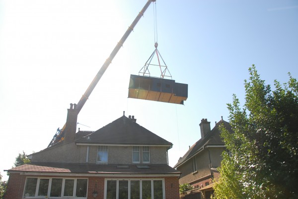 The mobile crane was positioned at the front of the house and lifted the modular building to its rear.
