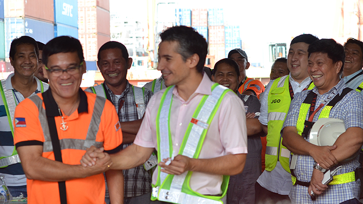 Christian R. Gonzalez (center), ICTSI senior vice president and head of Asia-Pacific and MICT, congratulates MICT quay crane operator Raldy Lido (left), one of the 40 new owners of a house and lot as of October this year. 