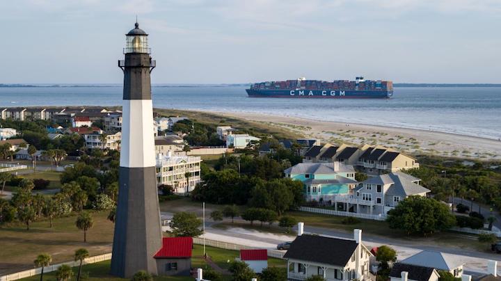 The CMA CGM Marco Polo crosses in front of the Tybee Island Lighthouse to enter the Savannah River channel Wednesday, May 26, 2021. The Port of Savannah served the CMA CGM Marco Polo, the largest vessel to ever call the U.S. East Coast, on Wednesday. The vessel has a carrying capacity of more than 16,000 twenty-foot equivalent container units. Featuring nearly 10,000 feet of contiguous dock space, 30 ship-to-shore cranes, and 1,345 acres of container yard space, the Port of Savannah’s Garden City Terminal is perfectly suited to handling vessels in the 16,000-TEU class.
