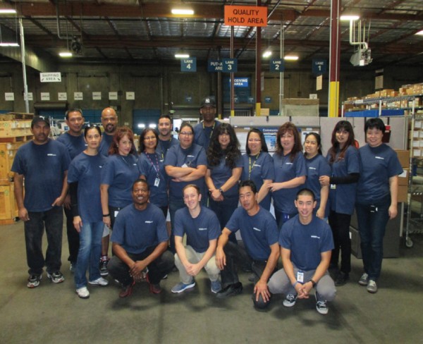 Employees at an RK Logistics distribution facility gather for a group picture marking the launch of the company's new website and updated brand