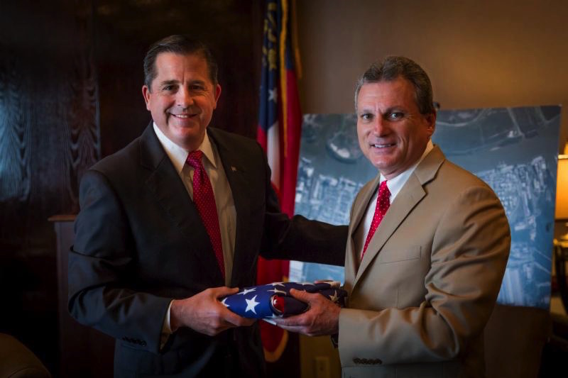 Congressman Buddy Carter presents outgoing GPA Executive Director Curtis Foltz (left) with a U.S. flag that has flown over the capitol in Washington D.C. Carter recognized Foltz' service to the state of Georgia during his final board meeting before stepping down June 30. Under Foltz' leadership, the GPA has reached major milestones, with the start of the Savannah Harbor Expansion Project and a 32 percent expansion in business over his six years at the helm of the GPA. (Georgia Ports Authority)