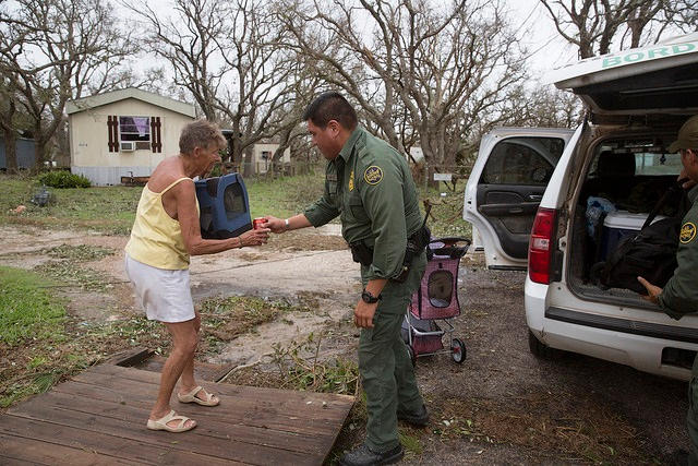 U.S Border Patrol agent Mario Fuentes rolls the belonging of a disaster survivor to a bus to evacuate her and her dog Chester in the wake of Hurricane Harvey. 