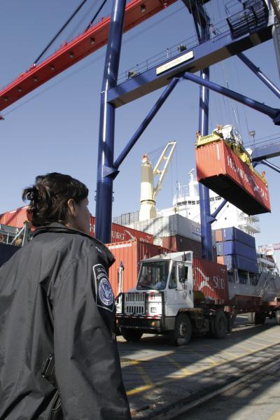 CBP officer watches as cargo is offloaded at the port.