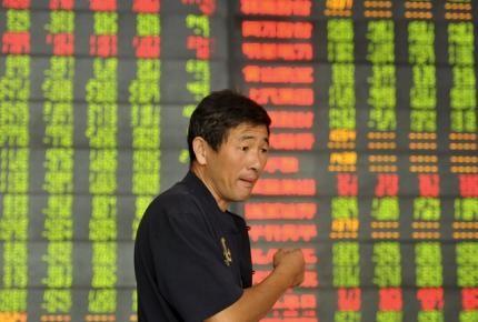  An investor speaks in front of an electronic board showing stock information at a brokerage house in Fuyang, Anhui province, China, September 14, 2015. Reuters/Stringer 