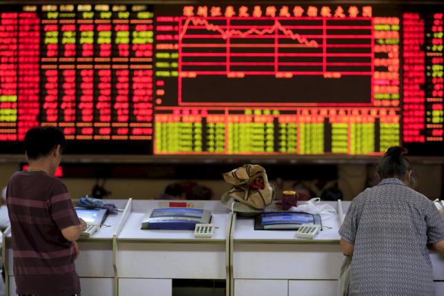  Investors look at computer screens in front of an electronic board showing stock information at a brokerage house in Shanghai, China, in this file picture taken September 7, 2015. Reuters/Aly Song/Files 