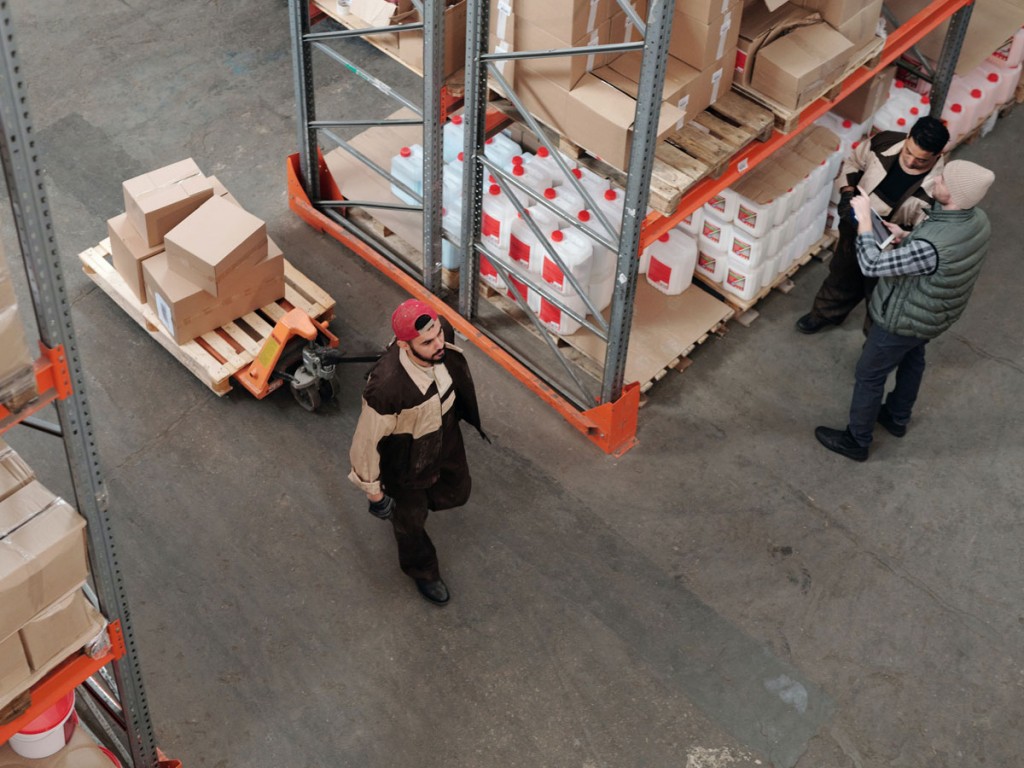 Warehouse workers witnessing the benefits of IoT in the global supply chain. 