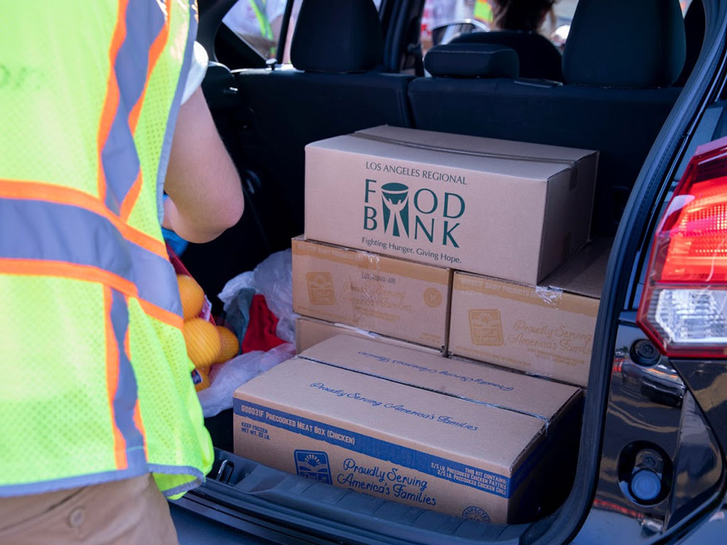 Due to health and safety protocols, volunteers will place the boxed groceries in car trunks and truck beds during the food distribution event sponsored by the Port of Long Beach, Labor Community Services and the Los Angeles Regional Food Bank.