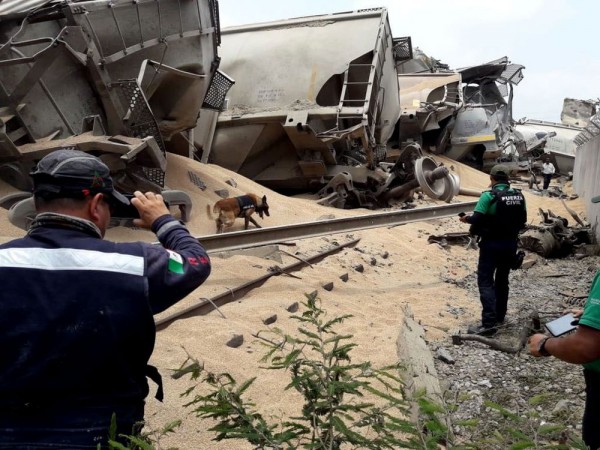 Police inspect a derailed train after it was looted. Source: Ferromex 