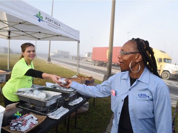 A Port of New Orleans employee serves hot breakfast to a professional truck driver who services Port properties during Truck Driver Appreciation Week.