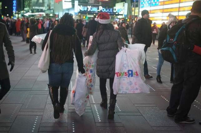  Women make their way though Times Square with bags of purchases from Toys R Us in New York November 27, 2014. Reuters/Carlo Allegri 