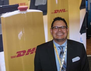 Adrian Kumar, global head of operations science and analytics for DHL Supply Chain, exhibits pride in warehouse robots at LINK2020: The Retail Supply Chain Conference. (Photo by Paul Scott Abbott, AJOT)