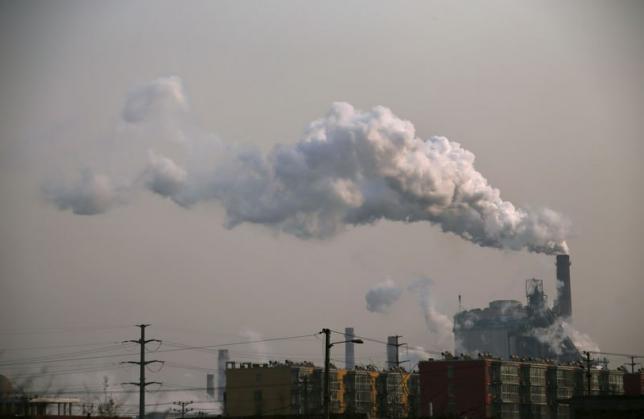  Smoke rises from a chimney of a steel plant next to residential buildings on a hazy day in Fengnan district of Tangshan, Hebei province in this February 18, 2014 file photo. Reuters/Petar Kujundzic/Files 