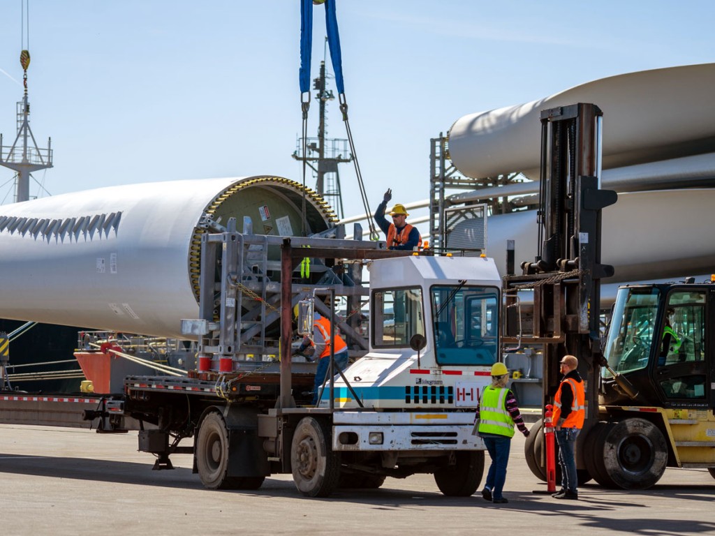 Expert workers from the ILWU ensure the safe, efficient placement of 250-foot-long wind energy blades on extended trailers